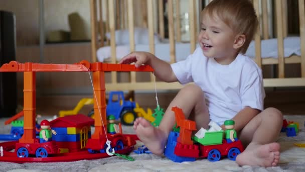 A criança brinca com os brinquedos na sala de jogos — Vídeo de Stock