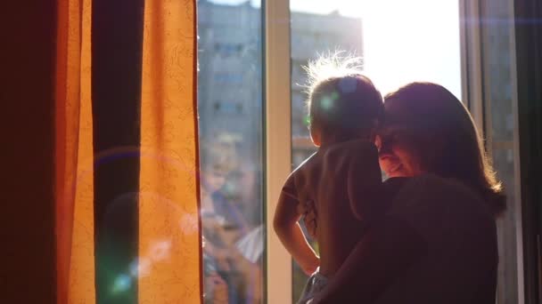 La chica en la ventana besando a un niño en el sol — Vídeos de Stock