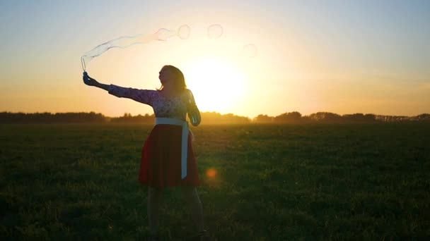 Dívka dává mýdlové bubliny při západu slunce — Stock video