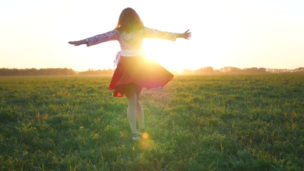 Chica en un vestido girando en la puesta del sol — Vídeos de Stock