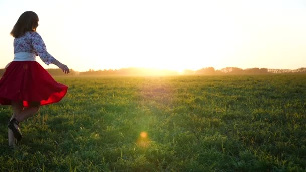 Hermosa chica en un vestido dando vueltas en la luz del sol — Vídeos de Stock