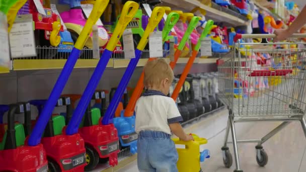 Een kind speelt in de speelgoedwinkel — Stockvideo
