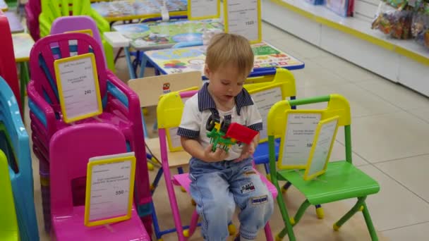 NOVOSIBIRSK, RUSSIE - 31 juillet 2016 : un enfant joue dans la boutique sur une chaise — Video