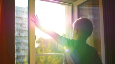 güneşin altında sallayarak pencereden çocuk