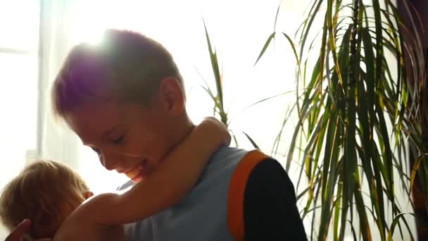 Kinder kuscheln und spielen zu Hause in der Sonne — Stockvideo