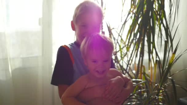 Kinder kuscheln und spielen zu Hause in der Sonne — Stockvideo