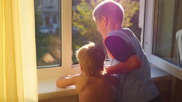 Діти дивляться у відкрите вікно — стокове відео