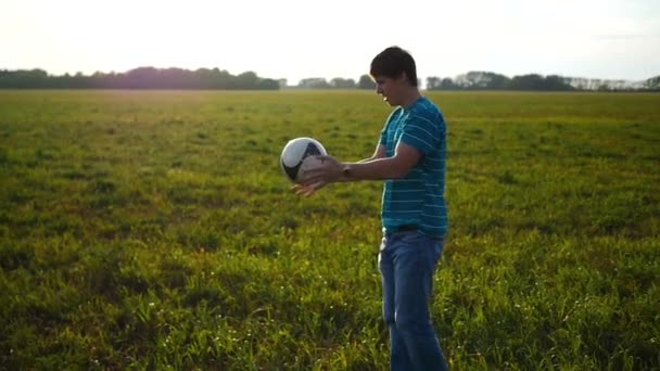 Hombre practicando con una pelota en el campo de fútbol — Vídeo de stock