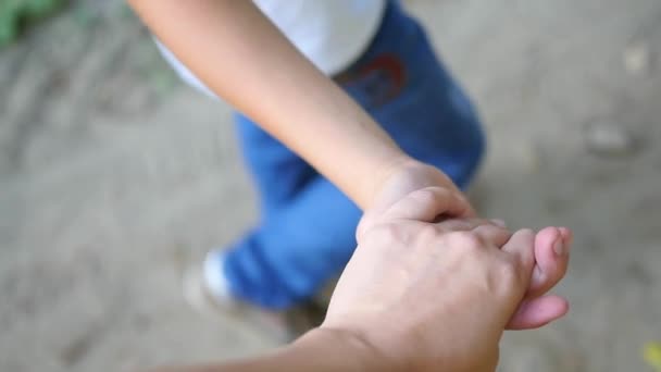 Дитина йде з мамою, тримаючись за руку — стокове відео