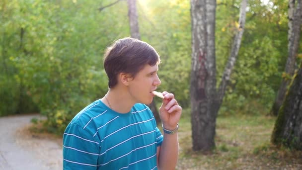 Il ragazzo mangia nel parco — Video Stock