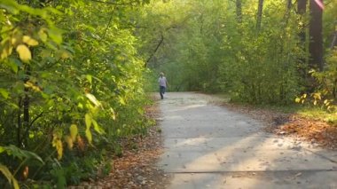 bir parkta bir yol boyunca çalışan çocuk