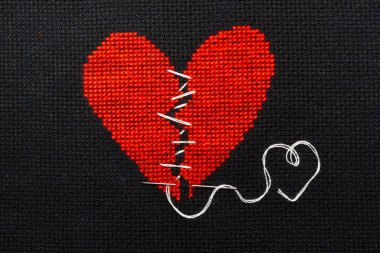 Red broken heart sewn with white thread. clipart