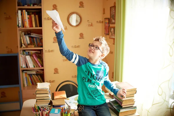 Menino com origami brinquedo avião em casa — Fotografia de Stock