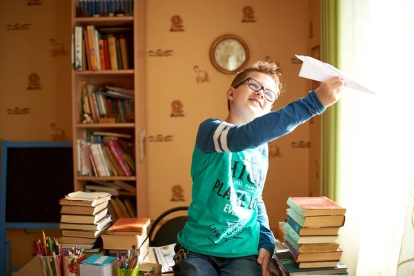 Junge mit Origami-Spielzeugflugzeug zu Hause — Stockfoto