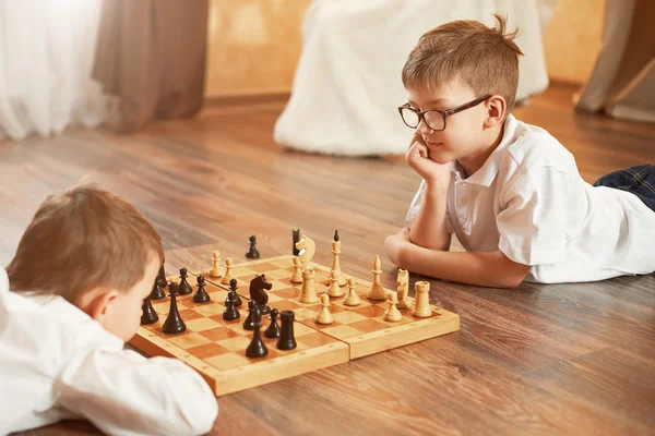 Two boy playing chess, studio, gray background — Stock Photo, Image