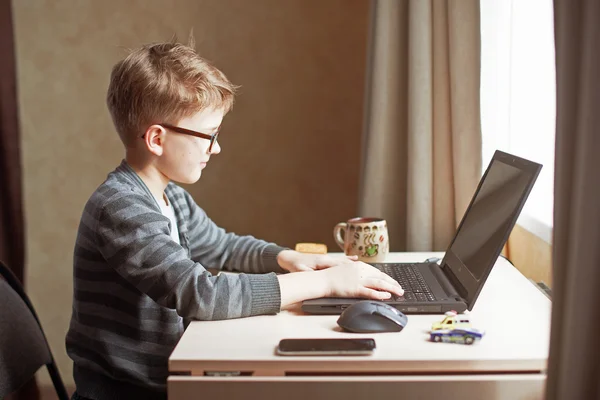Niño feliz sentado Con ordenador portátil —  Fotos de Stock