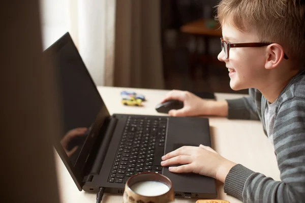 Niño feliz sentado Con ordenador portátil —  Fotos de Stock