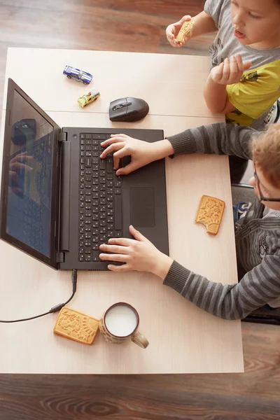 Niño feliz sentado Con ordenador portátil — Foto de Stock