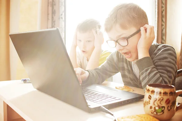 Niño feliz sentado Con ordenador portátil — Foto de Stock