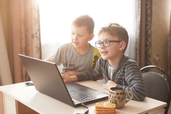 Niño feliz sentado Con ordenador portátil — Foto de Stock