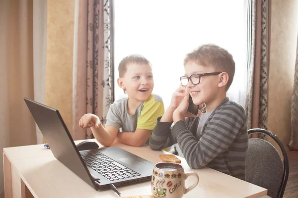 Niño feliz sentado Con ordenador portátil — Foto de Stock