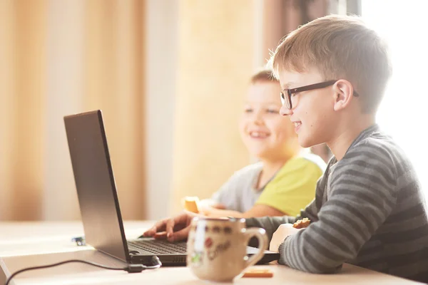 Niño feliz sentado Con ordenador portátil — Foto de Stock
