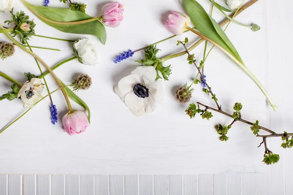 Flores de primavera diferentes em madeira branca e obturador — Fotografia de Stock