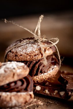Maroni cookies with pieces of chocolate on old wooden background