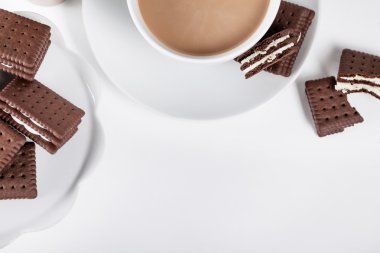 Beyaz tabak ve bir fincan kahve üzerine bisküvi