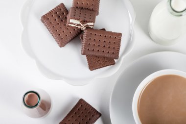 Cup of coffee and bottles of milk and chocolate milkshakes, top 