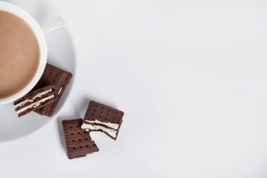 Biscuits on white plate and cup of coffee from the top