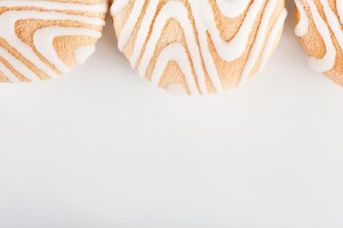 Beyaz arka planda beyaz buzlanma lı kurabiyeler, üst görünüm