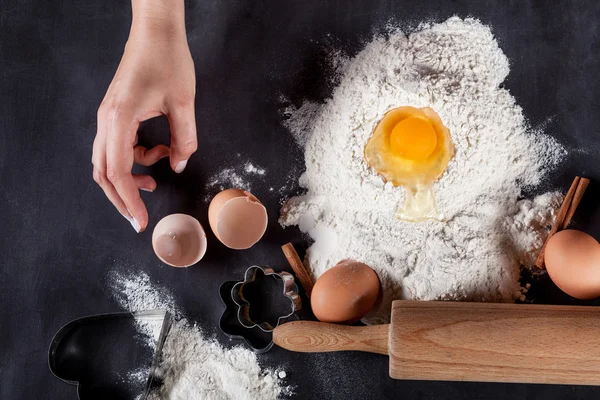 Baker is making  cookies with wooden rolling pin