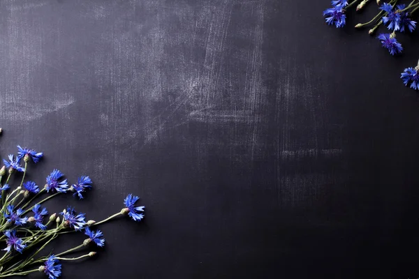 Niebieskich kwiatów na stare Tablica z zadrapaniami płaskie leżał — Zdjęcie stockowe
