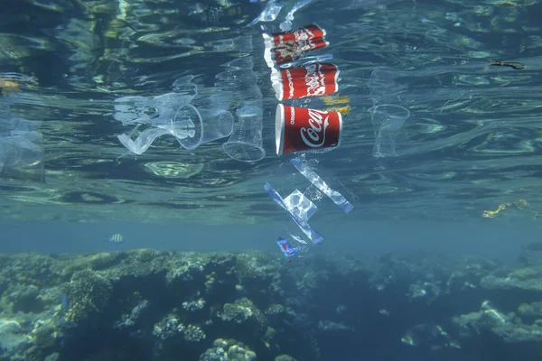 Plastic and other debris floats underwater near coral reef. Plastic garbage polluting seas and ocean