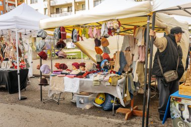 Açık hava pazarında parlak desenli ve renkli kürklü kış şapkaları ve çocuk kıyafetleri sergileniyor.. 