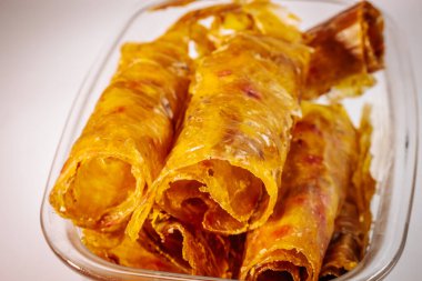 Altın sarısı yakın plan, parlak, çiğnenmiş dokusunu ve kurumuş katmanlarını gösteren cam bir kabın içinde saklanmış ayva meyvesi derisi..