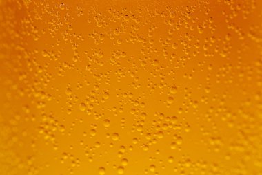 Aşırı yakın plan sarı-turuncu karbonatlı sıvı yükselen kabarcıklar desenli ve parlak bir arkaplan oluşturur.