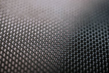 İnce parıltılı ve desenli yüzeyi olan sıkı örülmüş siyah sentetik kumaştan detaylı bir yakın çekim..