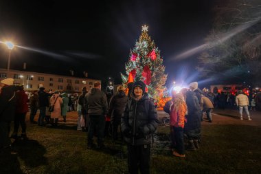 Geceleri, büyük, dekore edilmiş bir Noel ağacının etrafında ışıklar, dekorasyonlar ve kostümlü karakterlerle dolu bir kalabalık toplanarak sıcak bir festival atmosferi yaratıyor..
