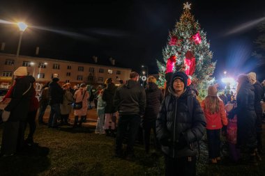 Geceleri, büyük, dekore edilmiş bir Noel ağacının etrafında ışıklar, dekorasyonlar ve kostümlü karakterlerle dolu bir kalabalık toplanarak sıcak bir festival atmosferi yaratıyor..