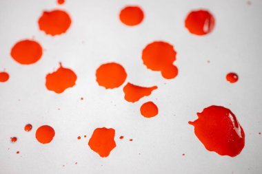 Farklı boyutlarda sayısız kırmızı boya lekeleri temiz, beyaz bir yüzeye dağılmış dinamik bir soyut desen yaratıyor..