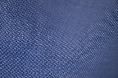 Tekstil tasarımı ve moda projelerinde kullanılmak üzere karmaşık dokuma desenleri gösteren mavi kumaşın ayrıntılı yakın çekimi