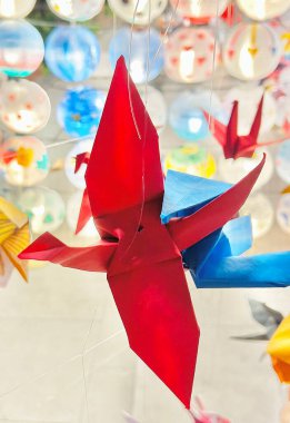 Kırmızı origami kağıt vinç ince bir iple askıya alındı.