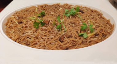 Stir-fried Hokkien noodles with soy sauce, shiitake mushrooms, and bean sprouts, served on a Chinese dining table.
