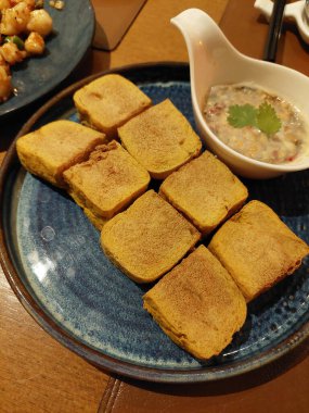 Tatlı ve keskin fıstık soslu kızarmış geleneksel tofu ve hafif acılı biber. Pirinç lapası restoranlarında ve Asya sokak yemekleri kültüründe yaygın olarak bulunan popüler abur cubur yemekleri..