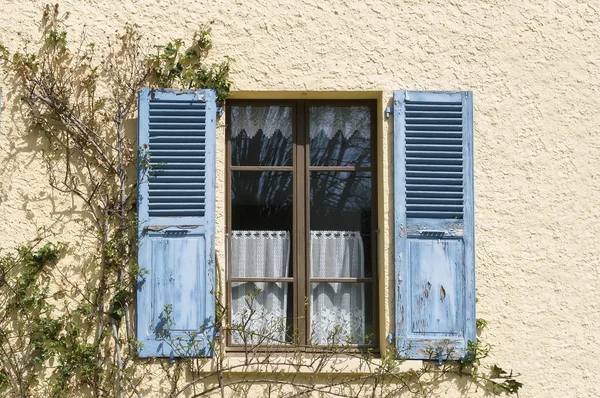 Pared beige con ventana de persianas azules — Foto de Stock