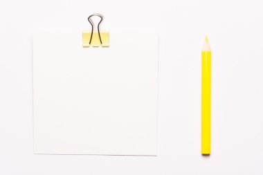 Beyaz not kağıdı ve beyaz zemin üzerine sarı ataç