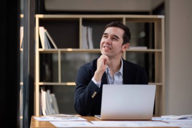 Dizüstü bilgisayar analisti ve yaratıcı tasarımcı üzerinde çalışan iş adamı kameraya bak ve gülümse. Bir dijital girişimci bir e-ticaret girişimi üzerinde çalışır..