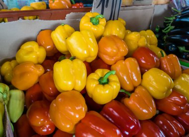 Renk, tat ve doğal tazelikle dolup taşan taşralı bir çiftçi pazarında taze sarı ve kırmızı çan biberlerinin canlı bir gösterisi.